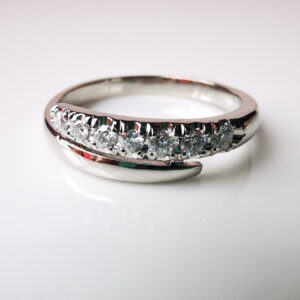 Alt: Anillo medio cintillo de platino con diamantes en degradé de tamaño.